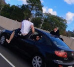 Wannabe stuntman attempts air-walking out of moving carsandtruck on Aussie highway