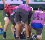 West Coast captain Oscar Allen helped from the field in hands of medical staff