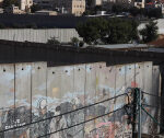 ‘I lost both legs’: Palestinians scale separation wall for chance to work