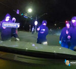 Masked mob attacks police cruiser with officer inside during illegal street takeover